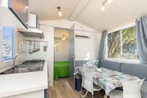 a kitchen and dining room with a table in a caravan at Campeggio la Mariposa in Alghero