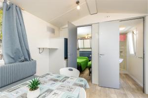 a small apartment with a table and a couch at Campeggio la Mariposa in Alghero +72 photos