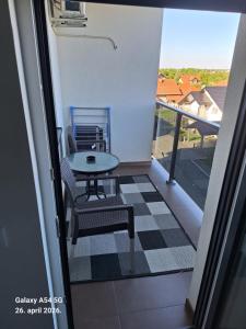 a balcony with a table and a chair on a floor at Stan na dan UNO Modriča in Modriča