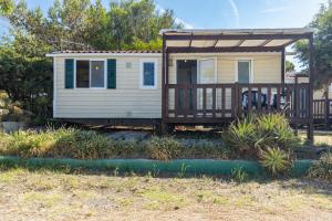 a tiny house with a porch and a deck at Campeggio la Mariposa in Alghero