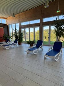 three chairs sitting in a room with windows at FeWo Luisa in Neureichenau