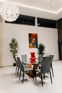 a dining room with a table with chairs and a vase at Hôtel Touraco in Assinie
