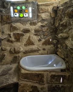 a stone bathroom with a tub in a stone wall at Green Nomad in Hogsback