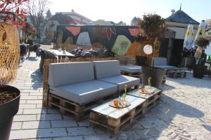 a couch on a patio with tables and chairs at Baumgartner Camping am Inn in Schärding