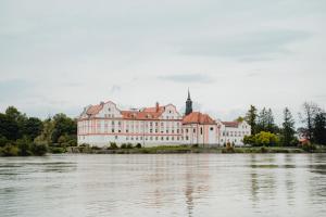 a large building on the banks of a river at Baumgartner Camping am Inn in Schärding