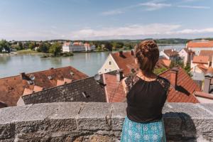 a woman standing on a wall looking at a river at Baumgartner Camping am Inn in Schärding