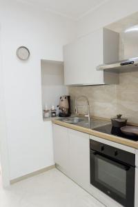 a kitchen with white cabinets and a sink at Dimora Don Ferdinando in Naples +38 photos