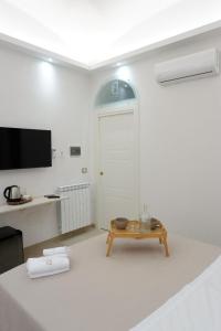 a white room with a table and a tv at Dimora Don Ferdinando in Naples