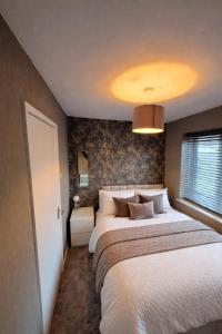 a bedroom with a large bed and a window at Stylish 2-Bed Flat, Minutes to Southport Centre in Southport