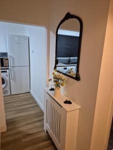a room with a mirror and a tv on a wall at Stylish 2-Bed Flat, Minutes to Southport Centre in Southport +6 photos