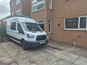 a white van parked in front of a brick building at Stylish 2-Bed Flat, Minutes to Southport Centre in Southport