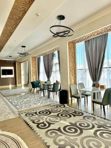 a living room with tables and chairs and a large rug at Argymak Hotel Karakol in Karakol