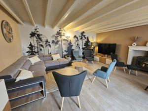 a living room with a couch and chairs and a tv at Villa nest in Saint-Sauvant