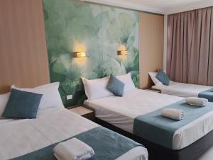 a hotel room with two beds and a mural at Airway Motel in Brisbane