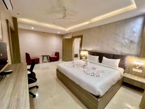 a hotel room with a large bed and a desk at Hotel Airport View in Pāsighāt +8 photos
