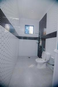 a bathroom with a toilet and a window at Zanzibar Residence in Zanzibar City