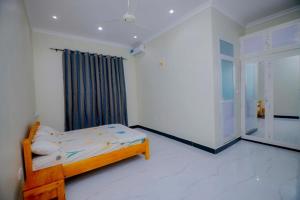 a bedroom with a bed in a room with a window at Zanzibar Residence in Zanzibar City