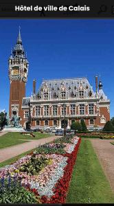 a large building with a clock tower and a clock at La casa valentine in Calais