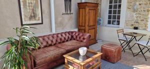 a living room with a brown couch and a table at Suite Majorelle du Château in Gaillan-en-Médoc