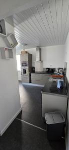 a large white kitchen with a counter in a room at La casa valentine in Calais +14 photos