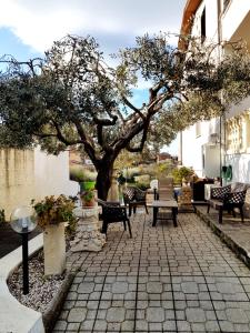 a patio with a tree and tables and chairs at Il Giardino Di Stella in Frascati