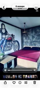 a poster of a bedroom with a motorcycle on the wall at Лофт в самом сердце Караганды in Karagandy