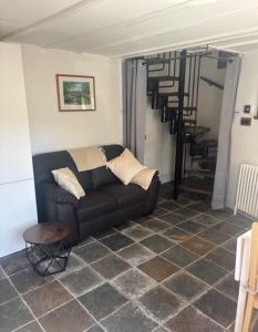a living room with a couch and a spiral staircase at The Old Stable in Abergavenny