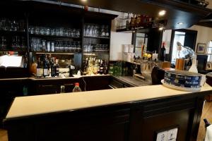a bar with a counter with a lot of alcohol at Hotel zum Freiheiter Hof in Raesfeld +17 photos