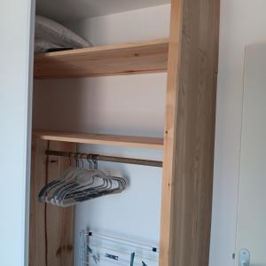 a closet with wooden shelves and a refrigerator at Kub in Trélévern