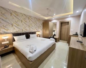 a bedroom with a large bed and a television at Hotel Airport View in Pāsighāt