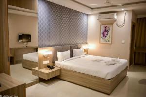 a hotel room with two beds and a tv at Hotel Airport View in Pāsighāt