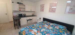 a bedroom with a bed and a kitchen with a microwave at Pearl Studio Apart - King Bed - Netflix - Projector - Fast Wi-Fi in Trier