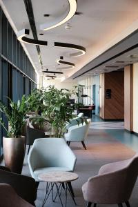 an office lobby with chairs and potted plants at Hunguest Hotel Bál Resort in Balatonalmádi +147 photos