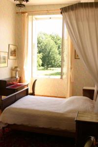 - une chambre avec un lit et une fenêtre dans l'établissement Château de Bois Renard, à Saint-Laurent-Nouan