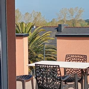 a patio with a table and chairs on a balcony at Kub in Trélévern
