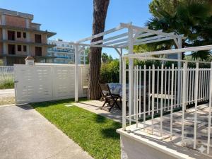 a white fence with a table in a yard at BEACH HOUSE - Premium Villas in Giulianova