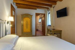 a bedroom with a white bed and a yellow door at Agriturismo Althea in Vittorio Veneto