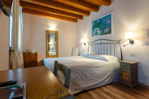a bedroom with a bed and a table and a mirror at Agriturismo Althea in Vittorio Veneto