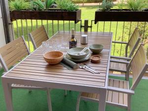 ein Holztisch mit Tellern, Gläsern und einer Flasche Wein in der Unterkunft viel Platz, 1-2 große Schlafzimmer, Küche mit Essplatz, Balkon, nahe Centro & Arena in Oberhausen
