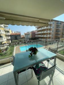 a blue table and chair on a balcony with a pool at Dolce Vita à Nice in Nice