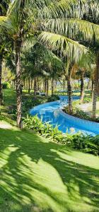 a swimming pool with palm trees in a park at Hà Lịch Light B0719 in Cam Ranh International Airport