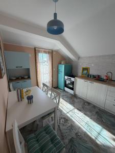 a kitchen with a white table and a blue refrigerator at Salaš Gnijezdo in Bačka Palanka