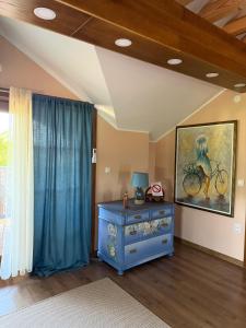 a room with a blue dresser and a painting on the wall at Salaš Gnijezdo in Bačka Palanka