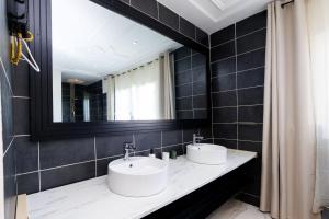 a bathroom with two sinks and a mirror at Duplex MNE in Douala +35 photos