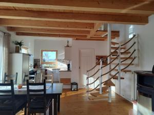 a kitchen and dining room with a spiral staircase at Ferienwohnung Landliebe in Reichertsried
