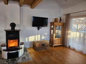 a living room with a wood stove and a tv at Ferienwohnung Landliebe in Reichertsried