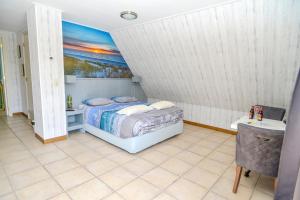 a bedroom with a bed and a painting on the wall at Bed en Bad De Koog in De Koog