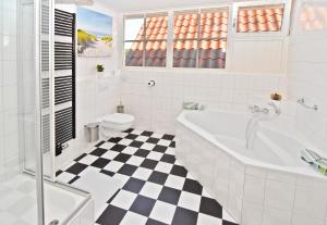 a white bathroom with a black and white checkered floor at Bed en Bad De Koog in De Koog