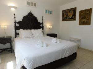 a bedroom with a large white bed with three pillows at Luz Beach Center in Luz