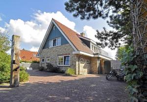 a brick house with a blue roof at Bed en Bad De Koog in De Koog